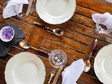 Plates and cutlery set on a wooden table.