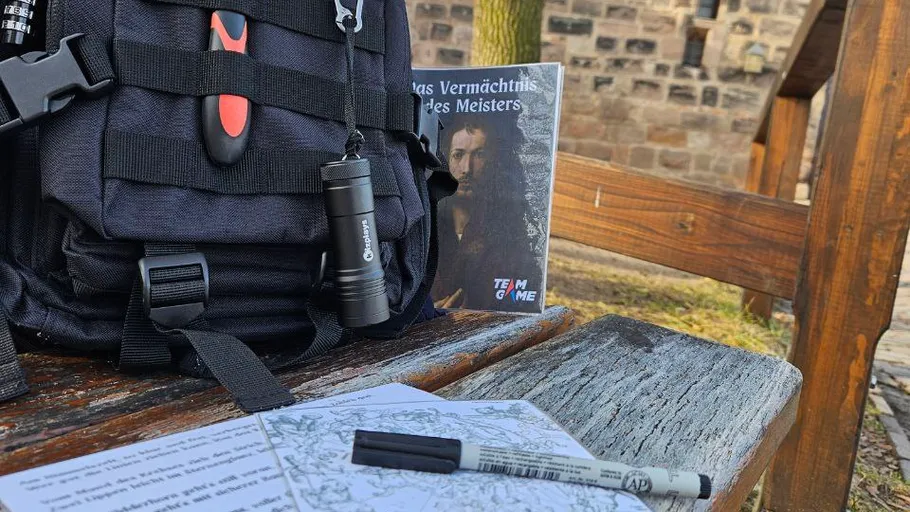 Rucksack, Taschenlampe, Buch auf einer Holzbank im Freien.