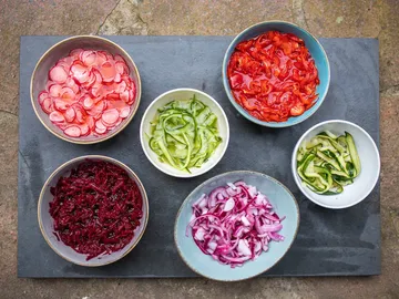 Colourful bowls of sliced vegetables on a table