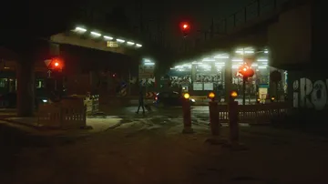 Nächtliche Straßenszene mit Auto unter der Brücke.