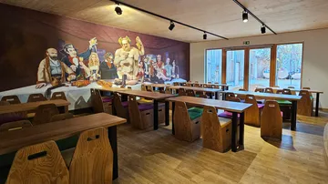 Restaurant interior with wooden tables and chairs.