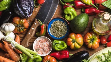Vegetables, knife, spices on wooden surface.