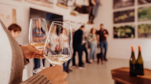 Person, die Weingläser bei einem Treffen in der Hand hält.