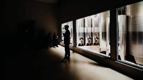 Ein silhouettierter Mann steht drinnen in der Nähe großer Tanks.