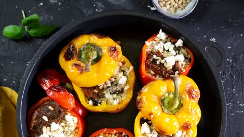 Gefüllte Paprika in einer schwarzen Pfanne.