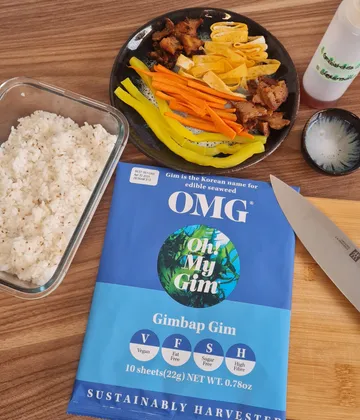 Zutaten für Gimbap, darunter Reis, Gemüse und Seetang.