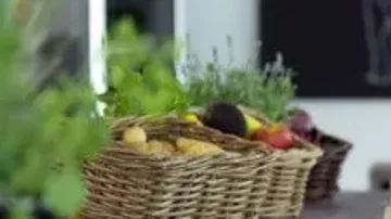 Wicker baskets filled with vegetables on table.