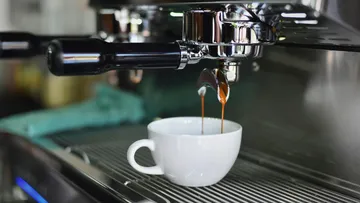 Espresso machine brewing coffee into a cup.