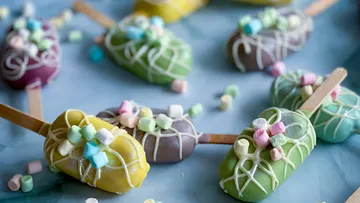 Verziertes Kucheneis am Stiel mit Marshmallows auf Stäbchen.
