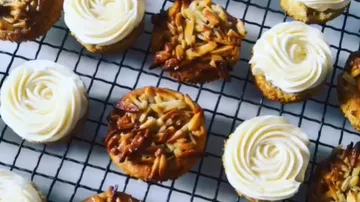Cupcakes mit Mandeln und Glasur auf dem Gestell.