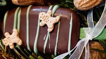 Schokolade mit Lebkuchendekorationen auf viel Grün.
