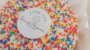 Cake with colorful sprinkles and a label.