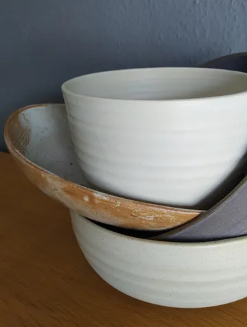 Stacked ceramic bowls on wooden surface.