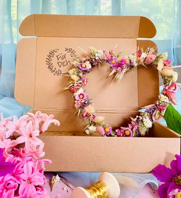 Herzförmiger Blumenkranz in Pappschachtel.