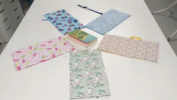 Colorful fabric cases around a book on table.