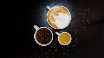 Three coffee cups on dark surface.