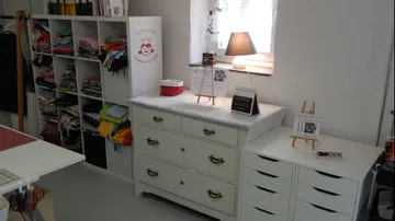 Nähzimmer mit Stoffablage und Schubladen.