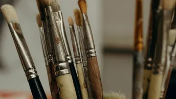 Paintbrushes in a jar, close-up view.
