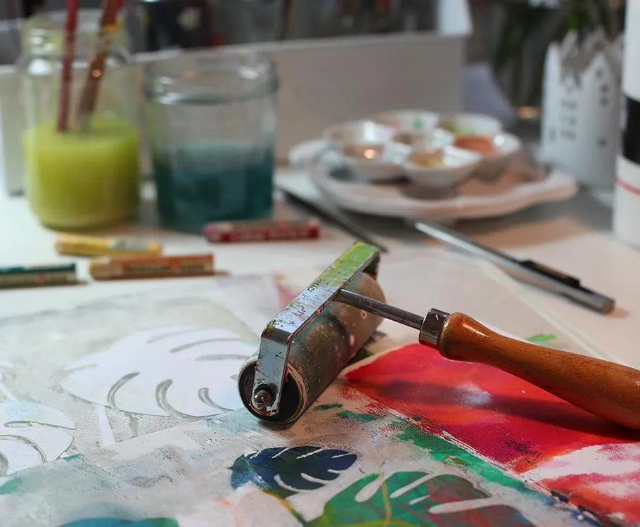 Paint roller on colorful art materials.