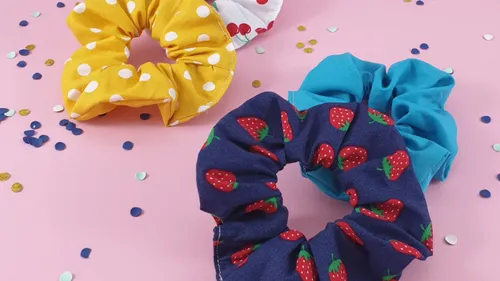 Colorful scrunchies on a pink surface.