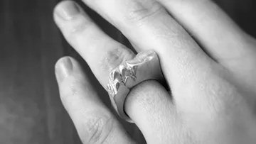 Hand wearing silver ring with star design