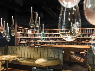 Elegant lighting hangs over a modern bar area.