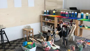Kunststudio mit Malutensilien und Pinseln.