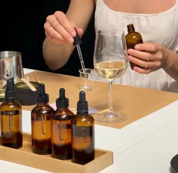 Person mischt Flüssigkeit mit Pipette und Flaschen.