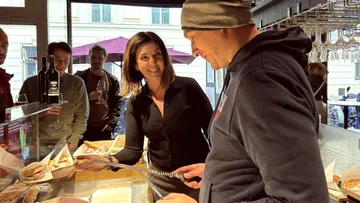 Frau lächelt Mann beim Schneiden von Essen im Café an.