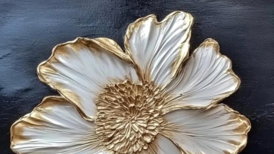 Goldene und weiße Blume auf schwarzem Hintergrund.
