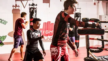 Kampfsportler trainieren in einer Fitnessstudio-Umgebung.