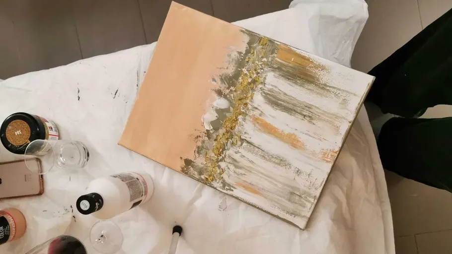Abstraktes Gemälde auf Tisch mit Kunstbedarf.