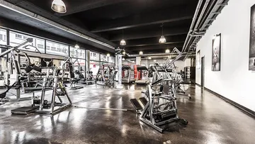 Leeres Fitnessstudio mit verschiedenen Geräten.