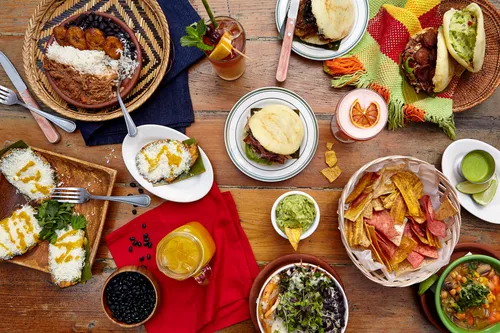 Assorted Latin American dishes on wooden table.