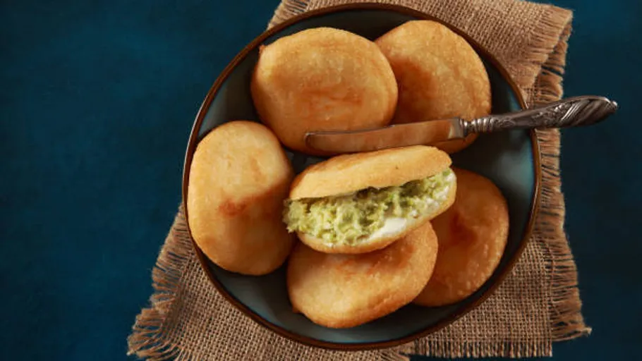 Teller mit Arepas und Avocadofüllung auf Jute.