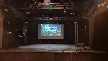 Bühne mit Bildschirm zeigt 'Singalong'-Event.