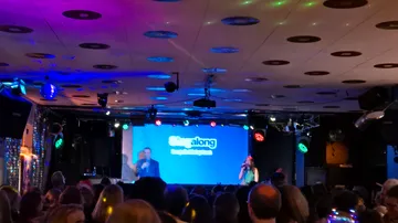 Leute singen auf der Bühne in einem Club.