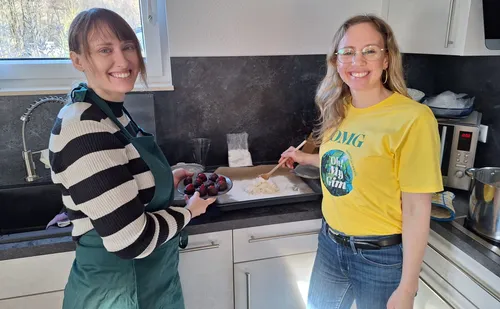 Two women cooking in a bright kitchen.