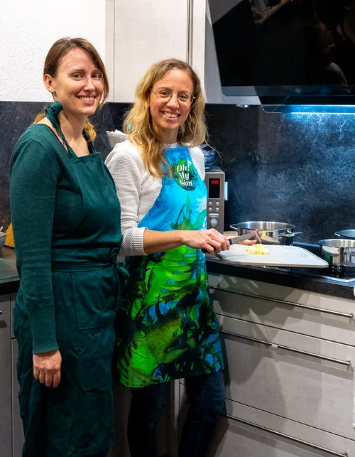 Two women cooking in a modern kitchen.