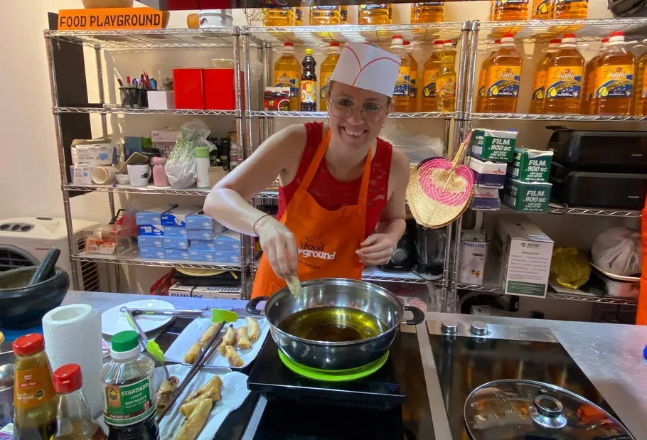 Person kocht in Küche, lächelt, bereitet Essen zu.