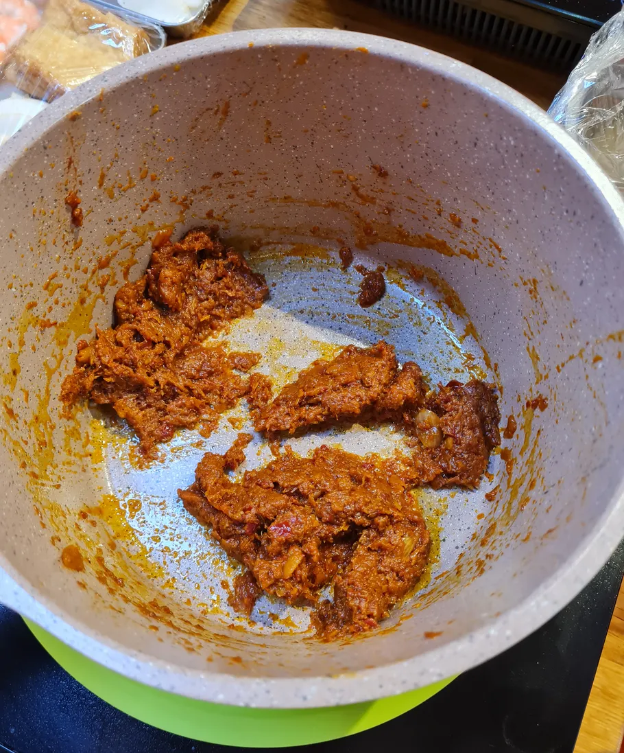 Brown stew in a cooking pot on stovetop.