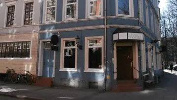 Blue building corner with bicycles and a door.
