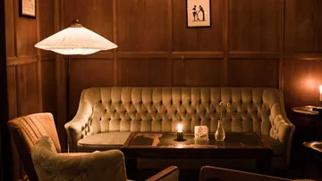 Cozy lounge with sofa and dim lighting.