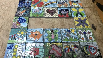 Colorful mosaic tiles arranged on a table.