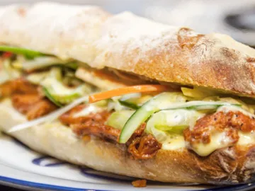 Ein Baguette mit Hähnchen, Gemüse und Sahnesoße.