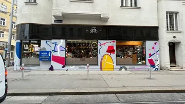 Bunte Fahrradladenfassade an einer Stadtstraße.