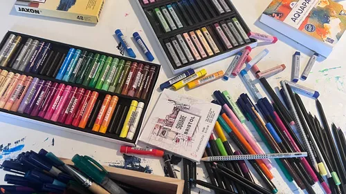 Art supplies including crayons, pens, and sketchpad.