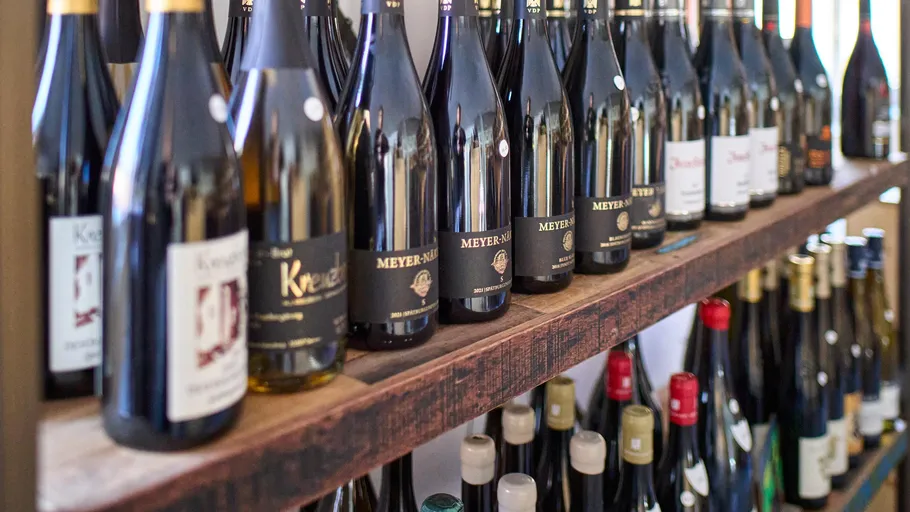 Wine bottles displayed on wooden shelves.