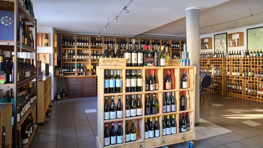 Wine bottles displayed on wooden shelves in a store.