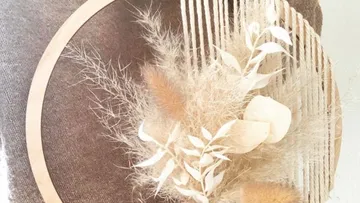 Decorative wreath with dried plants, brown background.